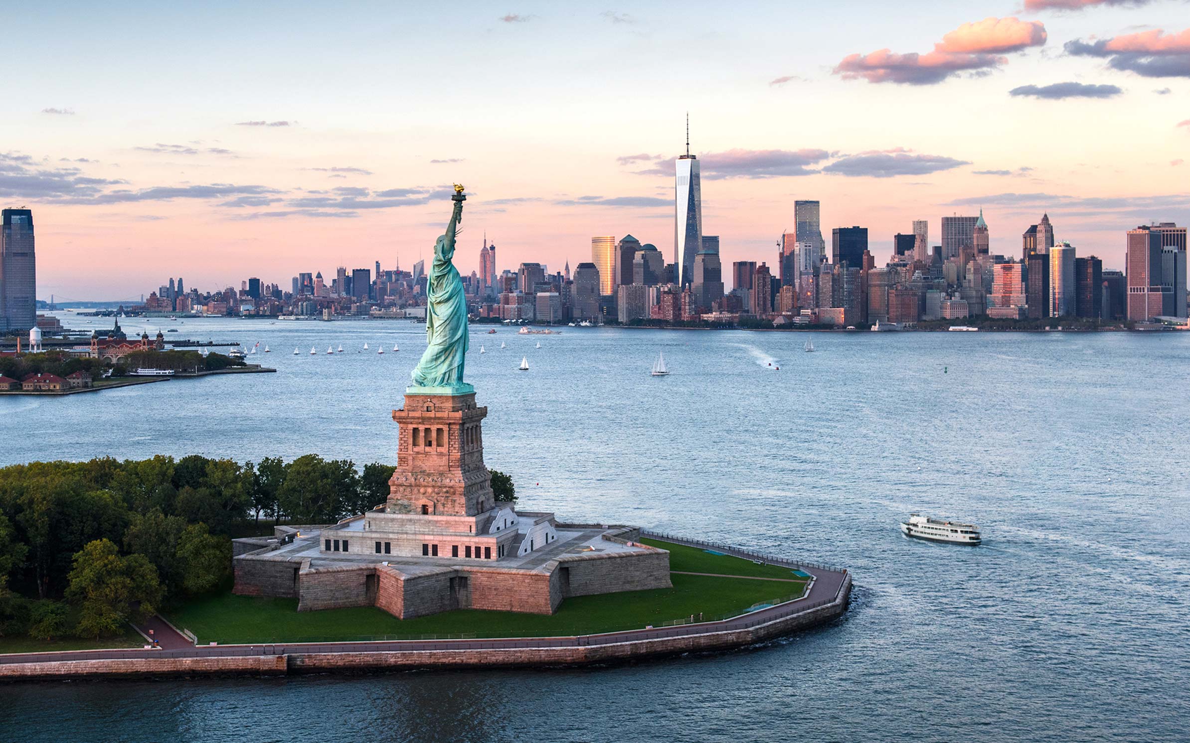 Statue of liberty in foreground next to Hudson River and Lower Manhattan in background