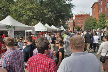 This is a crowd shot of Hamilton Park in Jersey City. It has white tents set up on the left side. This is a shot of the Hamilton Park BBQ Festival.