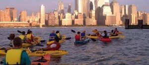 This is a picture of kayakers in the Hudson River overlooking Manhattan.