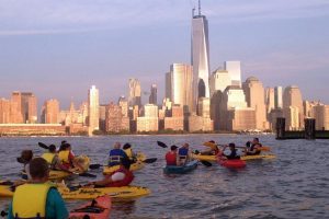 This is a picture of kayakers in the Hudson River overlooking Manhattan.