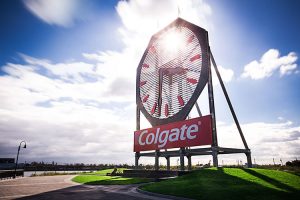 This is a picture of the historical colgate clock with a blue sky and a green grass foreground.