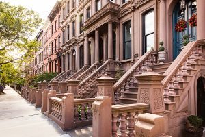 This is a photo of Hoboken brownstones in a row with gorgeous staircases leading to the grand entrances.