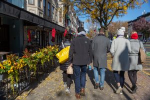 view of the backs of a group of people walking down the sidewalk