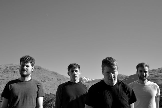 Black and white photo of four men band members