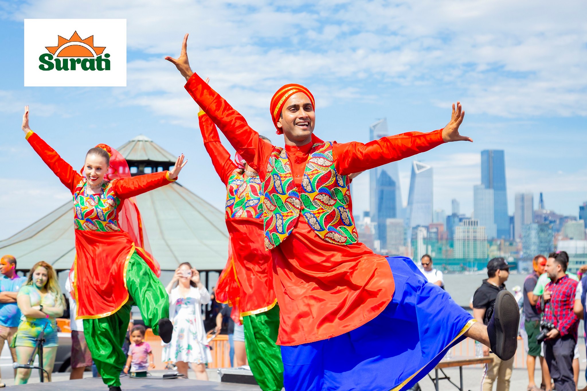 Surati dancers in matching cultural outfits performing near the waterfront