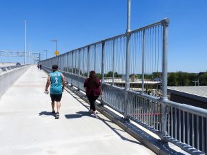 Man and women walking on the Bayonne Bridge Walkway