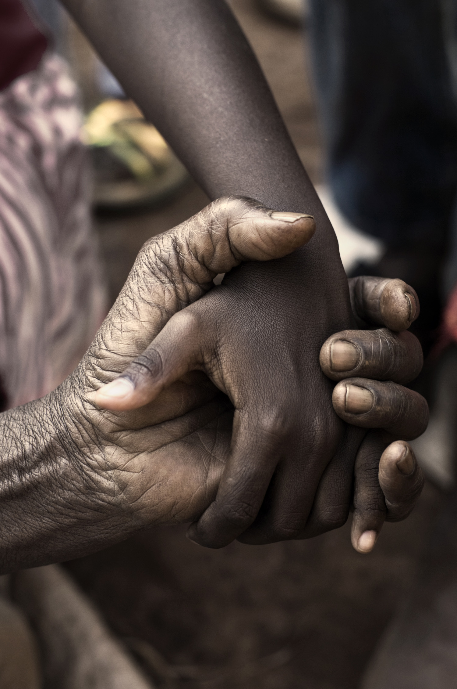 a young black male and older black male holding hands
