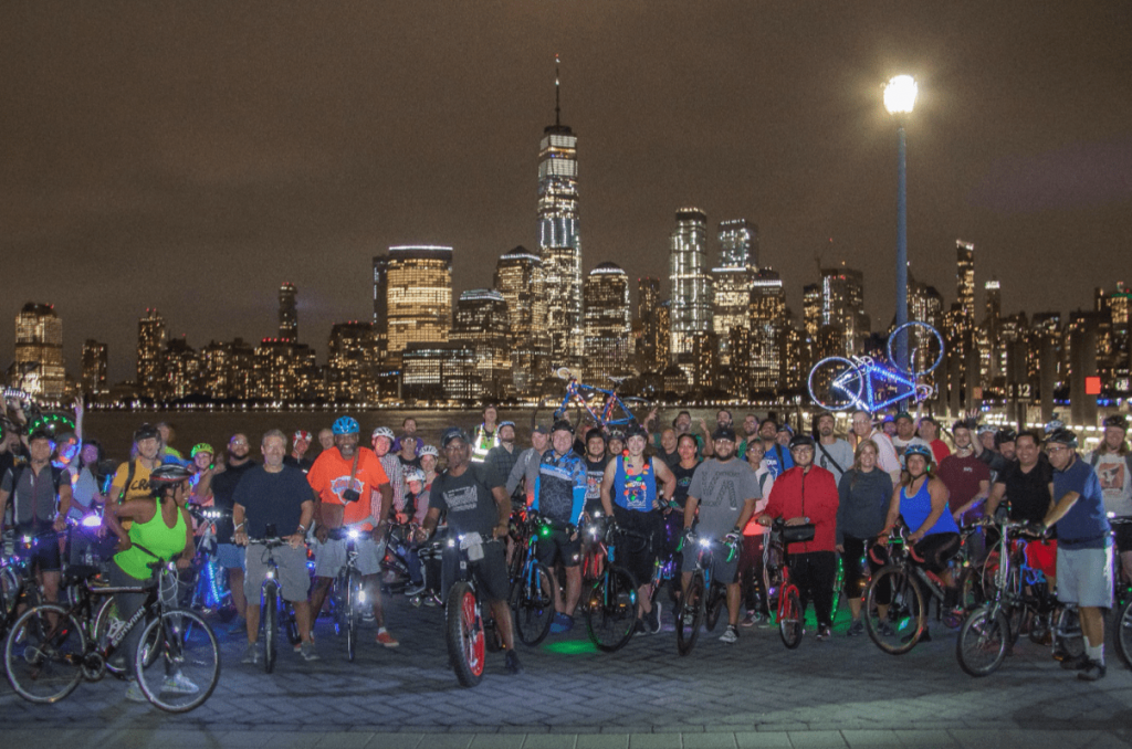 group of cyclists posing for a picture on the waterfront
