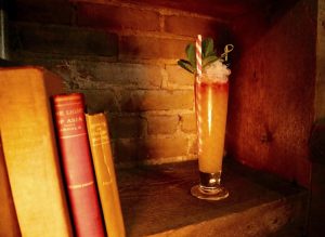 Cocktail on shelf with books at The Archer