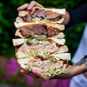 Person holding up four sandwich halves for picture