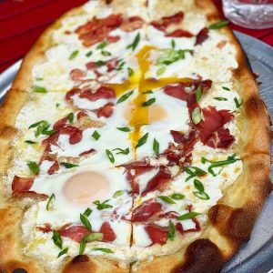 Pizza all'Uovo; brunch pizza with 2 baked eggs, prosciutto, bechamel, mozzarella, scallion, pecorino