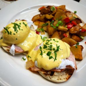 eggs benedict with a side of potatos