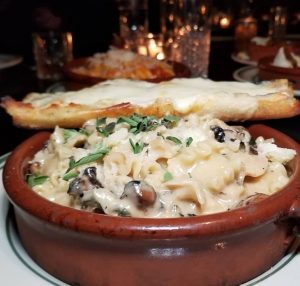 Bowl of lasagna edges with Italian bread from Antique Bar and Bakery