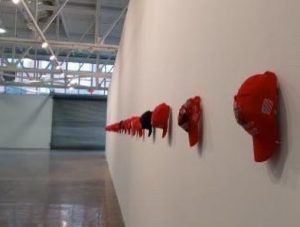 long row of red hats hung on a wall