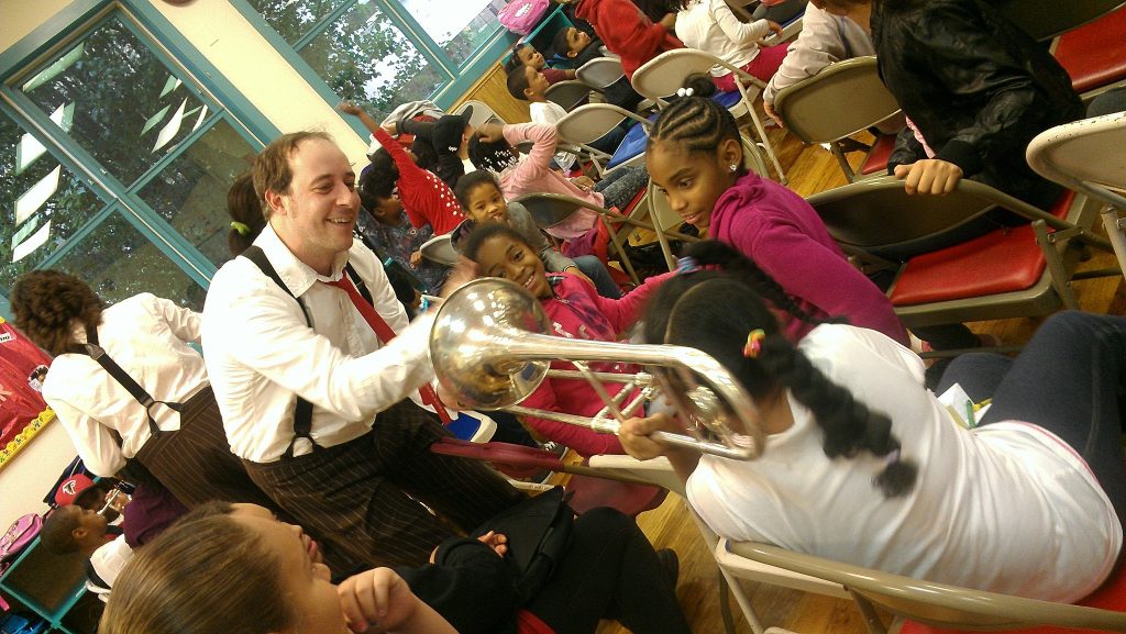 Man showing trombone to kids
