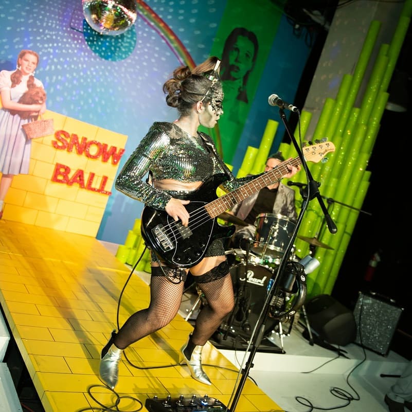 Woman playing guitar on stage at an Art House Productions event