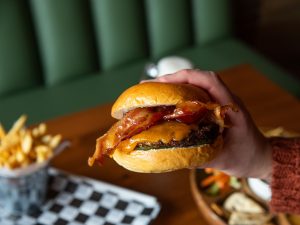 hand holding bacon cheeseburger