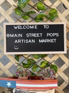 Sign with text "Welcome to @Main Street Pops Artisan Market"