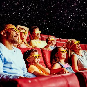 Audience enjoying a movie while wearing 3-D glasses.