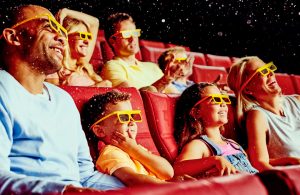 Audience enjoying a movie while wearing 3-D glasses.