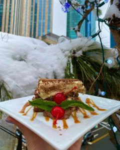 plate of dessert in front of a snow covered tree
