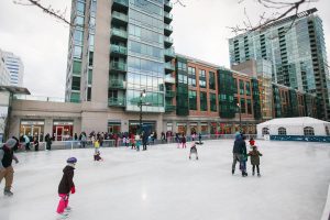 Outdoor skating rink with some people in winter attire skating on it