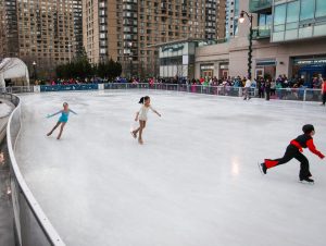 children ice skating on an outdoor rink