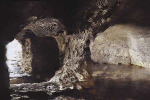 Inside Sybil's cave; dark rock cavern with low arches