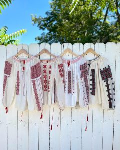 vintage shirts hanging off a white fence