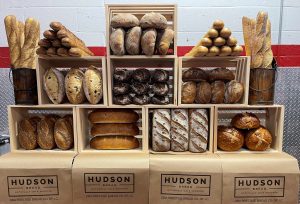 breads sorted into creates on a table with the "Hudson Bread" logo 