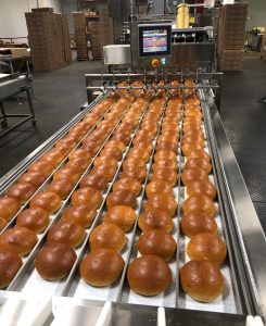 breads coming out of a factory oven