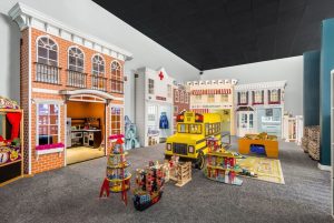 life-size play set neighborhood made up of fake storefronts on the walls and an open area with toys