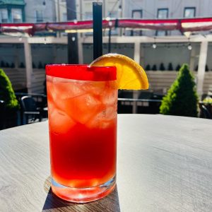 red cocktail with a lemon slice