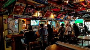 Inside the irish bar, Mulligan;s pub; group of man seated at each stool along the bar