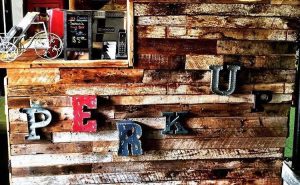 wood wall with industrial style letters that read "Perk Up"