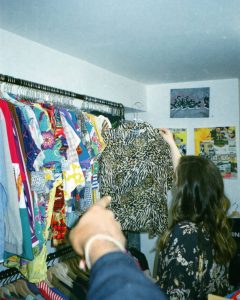 hand pointing to an animal print shirt that a woman is holding up