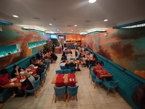 inside Beyti Kebab restaurant with casual blue and red dining tables