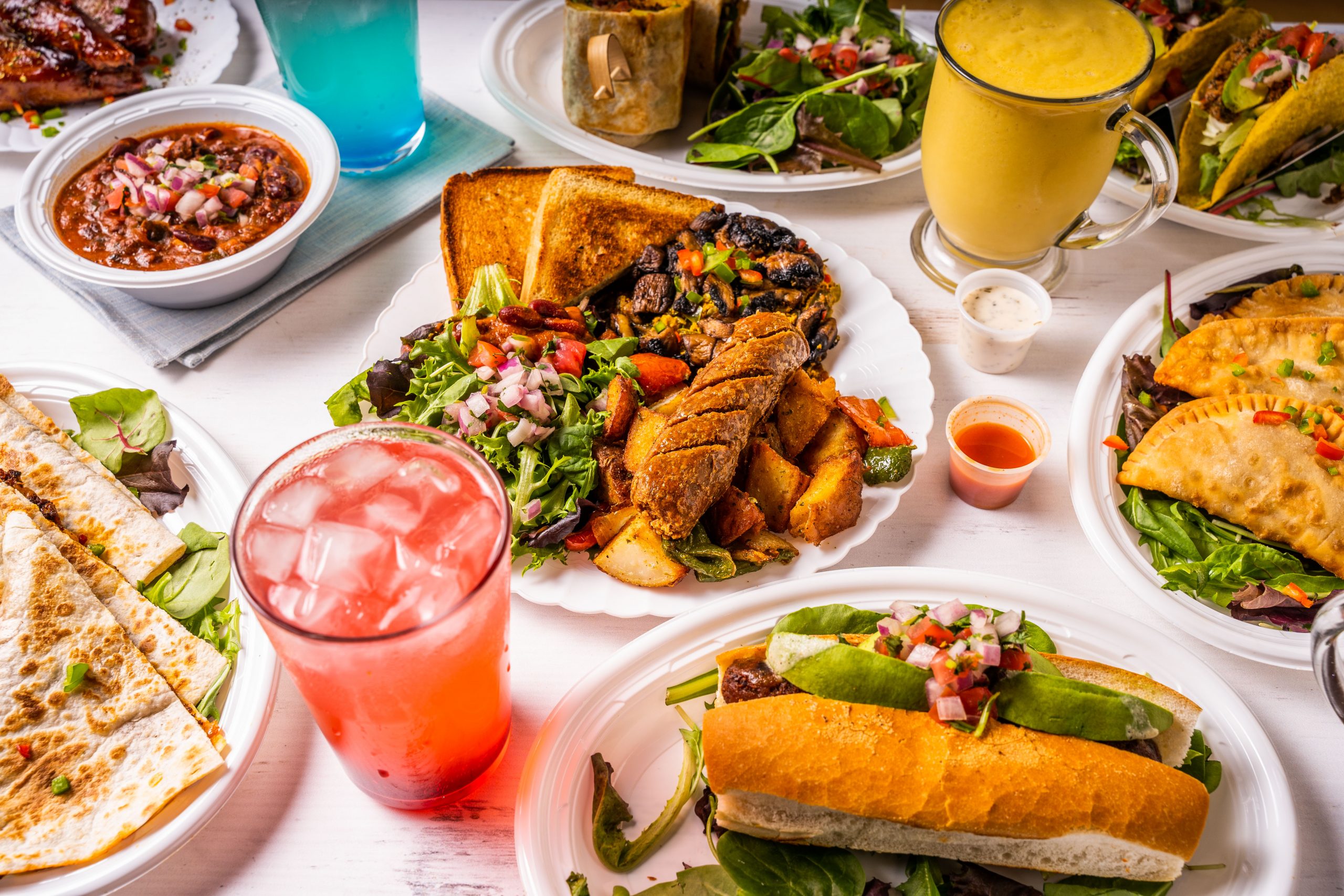 table filled with multiple plates of vegan entrees 