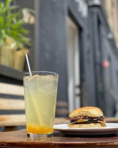 glass of an iced drink and a burger