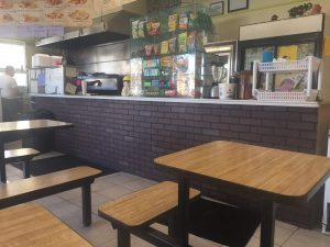 Inside Laisha's Coffee Shop, picnic style table seating area