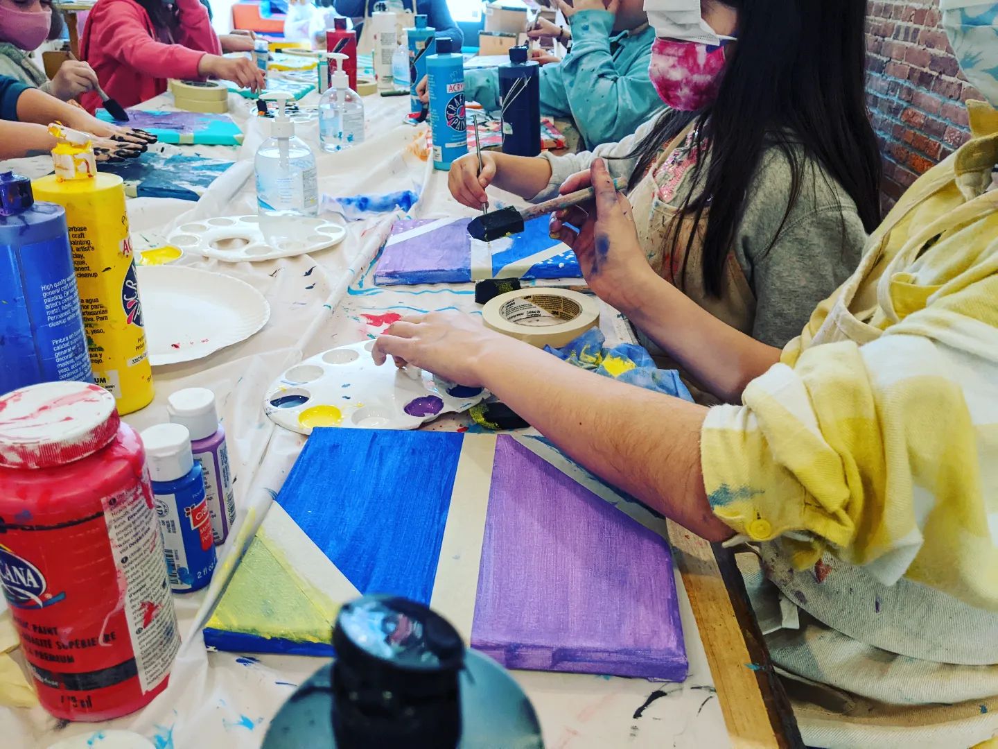 Long table filled with kids painting