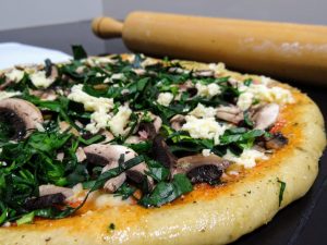 bread topped with mushrooms, spring greens, and cheese