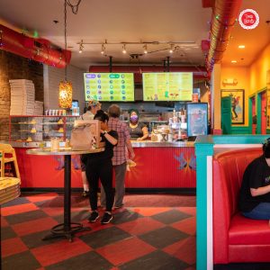 Inside Two Boots pizzeria where customers are lined up to give their order 