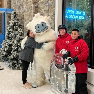 family takes a picture with the Big Snow mascot, a yeti