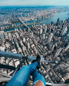 legs dangling from a helicopter over New York City