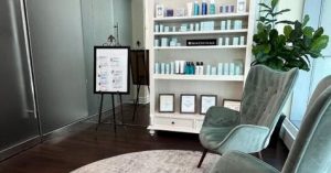 Image of the Reception Area at Hoboken Spa, with chair in front of products for sale and sign with list of services