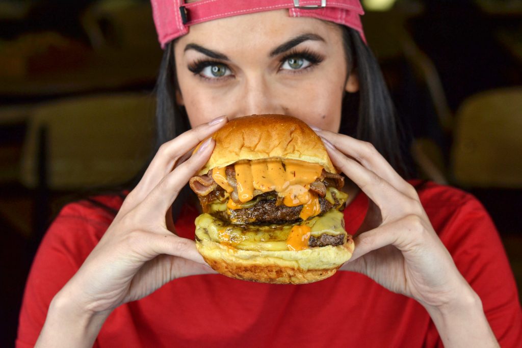 woman eating bacon cheeseburger at Kings of Kobe